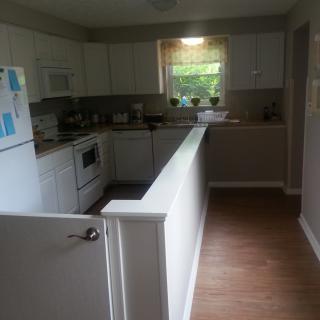 A cozy kitchen with white cabinets and modern appliances.