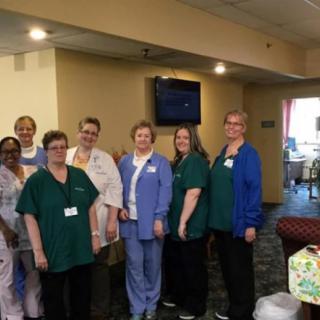 A group of healthcare professionals in a hospital setting, wearing uniforms.