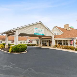 The entrance of a hotel with a covered driveway and well-maintained landscaping.