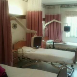 A hospital room with neatly arranged beds and medical equipment.