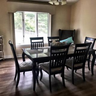 A cozy dining room with a large table and chairs near a bright window.
