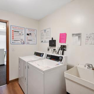 A well-equipped laundry room featuring washing machines and a utility sink.