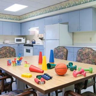 A kitchen setting with various children's toys scattered on the table.