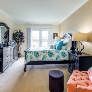 A cozy bedroom with elegant furnishings and a large window letting in natural light.