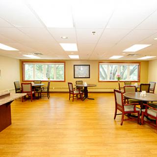 A bright and spacious office-style room featuring wooden flooring and large windows.