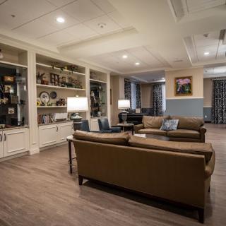 A cozy living room with comfortable sofas, bookshelves, and warm lighting.