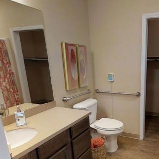 A bathroom with a sink, mirror, and accessible features.