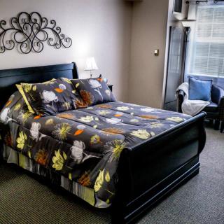 A cozy bedroom with a patterned bedspread and elegant decor.