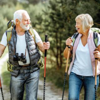 An elderly couple hiking through a forest trail, enjoying nature and staying active.