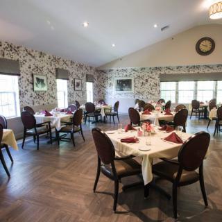 An elegant dining area with neatly arranged tables and chairs, featuring tasteful decor.