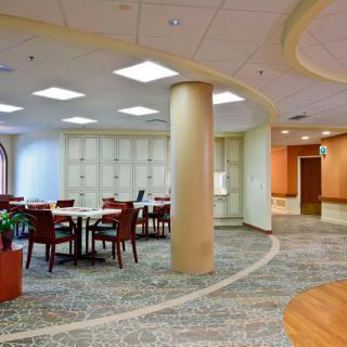 A modern meeting room with a large conference table and comfortable seating, featuring contemporary design and bright lighting.