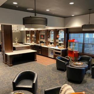 A modern lounge with comfortable seating and a kitchen area.