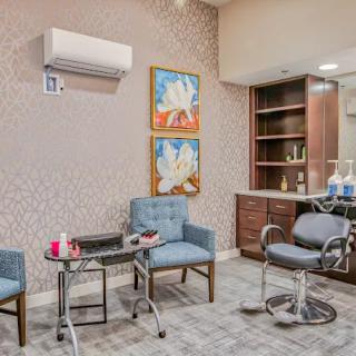 A modern salon interior with stylish chairs, artwork on the walls, and a well-equipped hairdressing station.