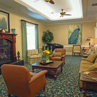 A cozy living room with comfortable seating, decorative artwork, and a coffee table adorned with flowers.