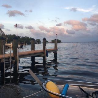 A serene lake view at sunset with a dock and boat in the foreground.