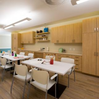 A modern kitchen interior with wooden cabinets, a large table, and chairs.