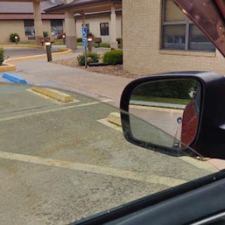 A view of a parking lot reflected in the side mirror of a car.
