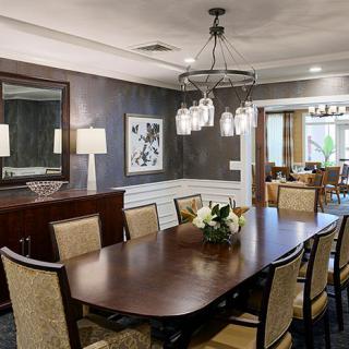 A well-appointed dining room with a wooden table, upholstered chairs, and elegant lighting.