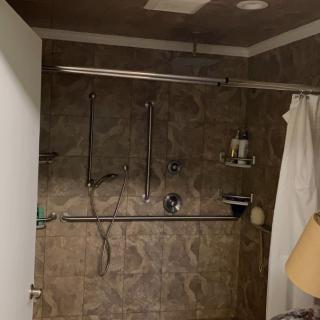 A bathroom featuring a shower with a curtain and tiled walls.