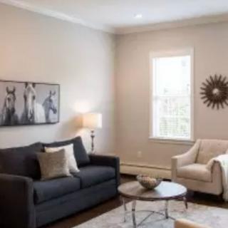A cozy living room with a dark sofa, cream armchair, and stylish decor.