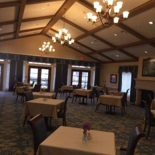 An elegant dining room with neatly arranged tables and chandeliers.