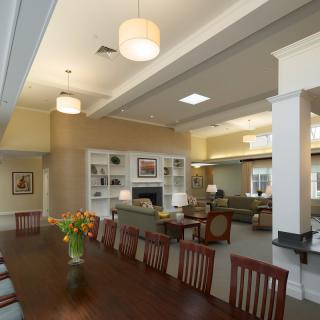 A spacious and modern interior featuring a living room and dining area with elegant furnishings and warm lighting.