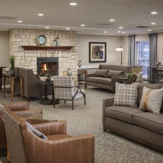 A cozy living room featuring comfortable sofas, a stone fireplace, and elegant home decor.