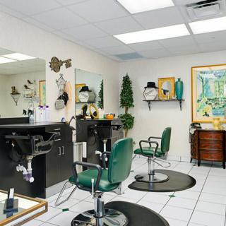An interior view of a hair salon with green chairs and mirrored stations.
