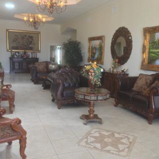 A spacious and elegantly decorated living room featuring ornate furniture and artwork.