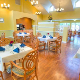 A well-lit dining area with neatly arranged tables and chairs.