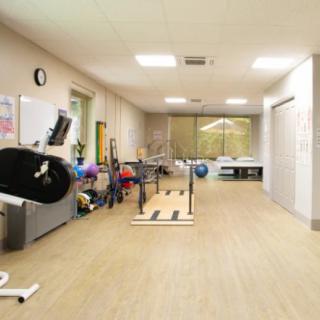 A spacious gym with various exercise equipment and facilities for fitness training.