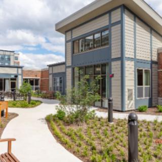 A modern architectural building with landscaped pathways and benches.