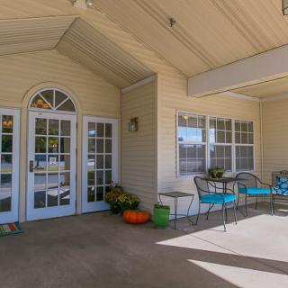 A welcoming outdoor porch with seating and seasonal decorations.