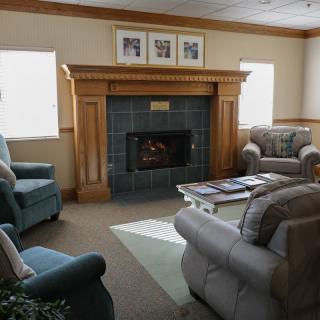 A cozy living room with a fireplace surrounded by comfortable seating and a coffee table.