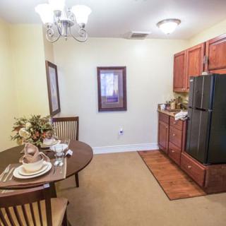 Cozy kitchen and dining area with a small table setting and wooden cabinetry.
