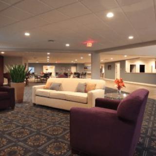 A spacious lobby area featuring comfortable sofas and armchairs, soft lighting, and stylish decor.