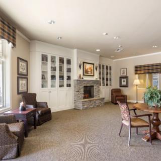 A cozy living room featuring a stone fireplace, comfortable seating, and elegant interior design.