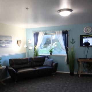 A cozy living room with a sofa, television, and decorative elements.