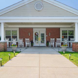 A welcoming porch with rocking chairs in front of a brick house entrance.