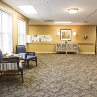 A quiet lobby area with chairs and carpeted flooring.