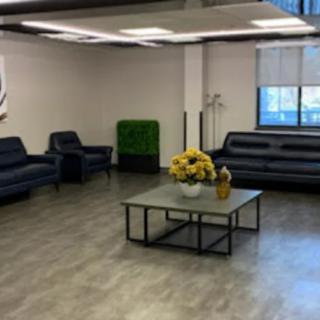 A spacious waiting area featuring comfortable sofas and a central coffee table with a floral arrangement.