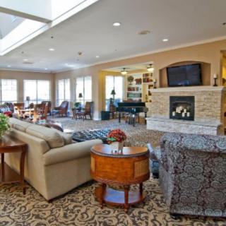 A spacious and elegantly decorated living room with a fireplace and ample seating.
