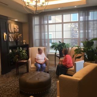 Two people sitting in a cozy lounge area having a conversation.