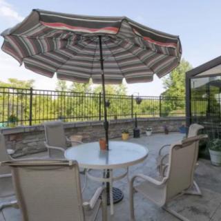 A cozy outdoor patio with a table, chairs, and a large umbrella.