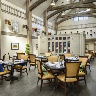 A spacious restaurant interior with elegant decor and neatly arranged tables and chairs.