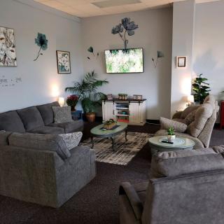 A cozy living room with sofas, coffee tables, and decorative plants.