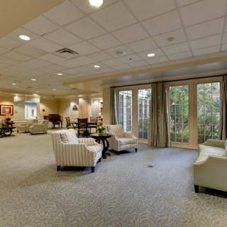A spacious lounge area featuring comfortable seating and large windows looking out onto greenery.