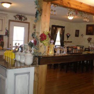 A cozy dining area with wooden floors, decorated tables, and chandeliers.