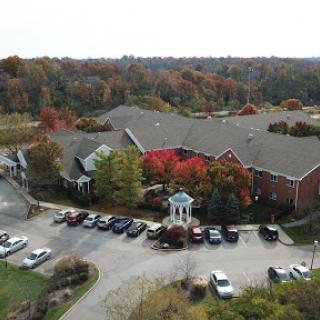 Aerial view of a residential building surrounded by vibrant autumn colors.