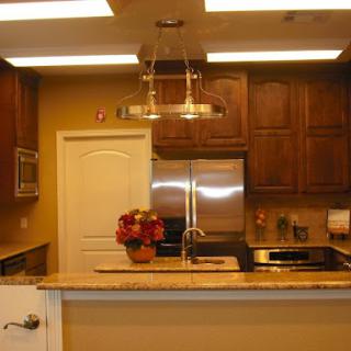 A modern kitchen featuring wooden cabinets, stainless steel appliances, and warm lighting.
